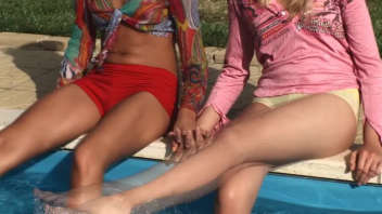 Belles femmes s'ébattant à la piscine : Profitez d'un moment coquin au soleil avec ces deux femmes séduisantes.
